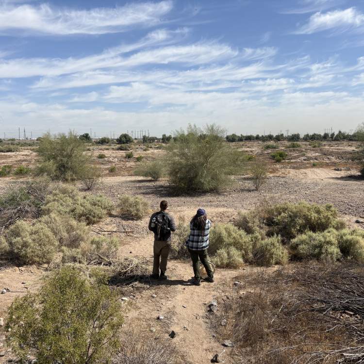 man and women stand along riverbed