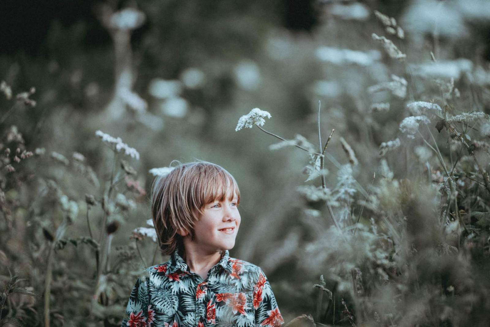 child smiling amid plants